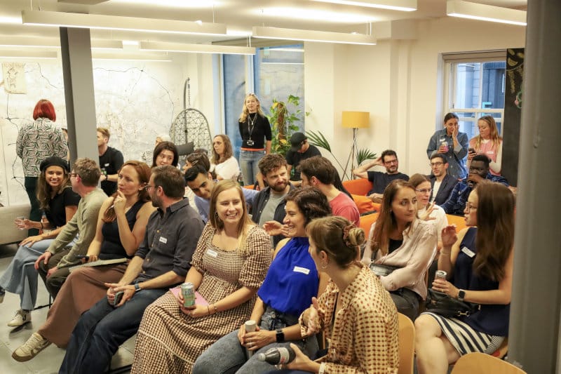 A room full of people talking and laughing at a Generalist World meetup
