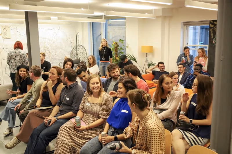 A room full of people talking and laughing at a Generalist World meetup
